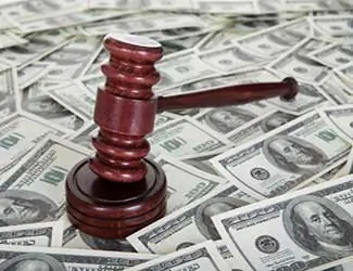 Mazo de juez descansando sobre una pila de billetes de dólares estadounidenses