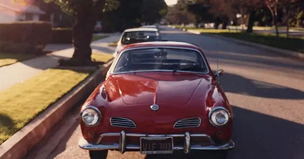 Volkswagen Karmann Ghia coupé rojo brillante de 1967 estacionado en una calle residencial
