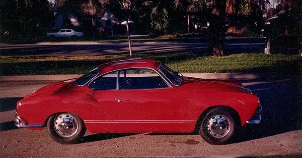 Volkswagen Karmann Ghia rojo brillante de 1967 estacionado en una calle residencial